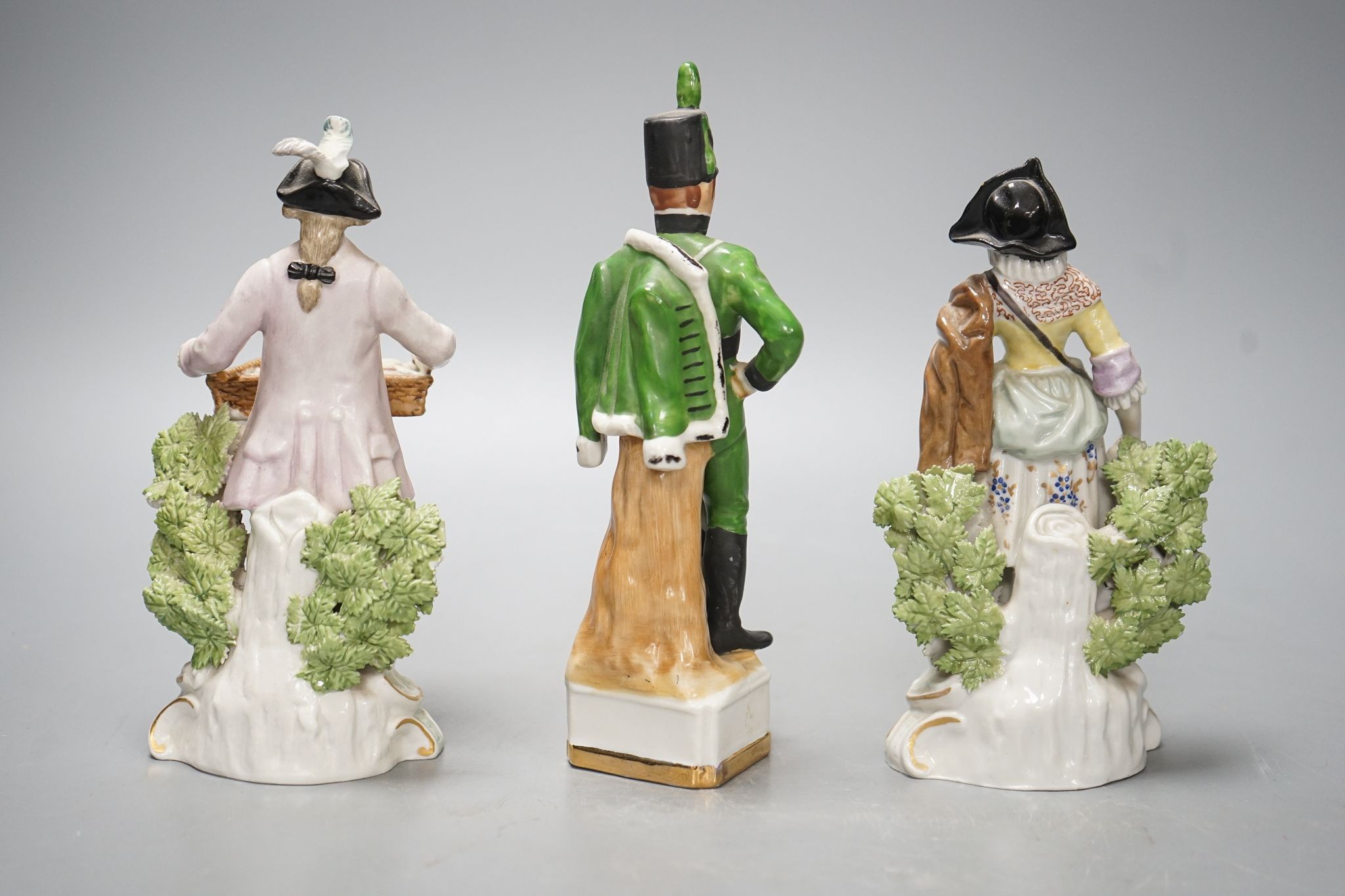 A pair of Dresden porcelain figures of a street-trader and companion and a continental porcelain figure of a Rifle Brigade officer (3) 19.5cm